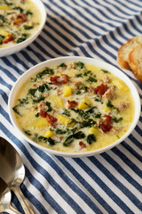 Homemade Zuppa Toscana with Kale and Bread in a white bowl, low angle view.