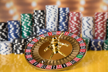 Poker Chips on gaming table, roulette wheel in motion, casino background