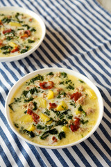 Homemade Zuppa Toscana with Kale and Bread in a white bowl, side view.