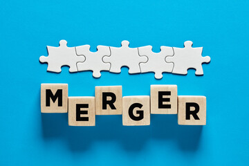 Merger and acquisition in business concept. The word merger on wooden cubes
