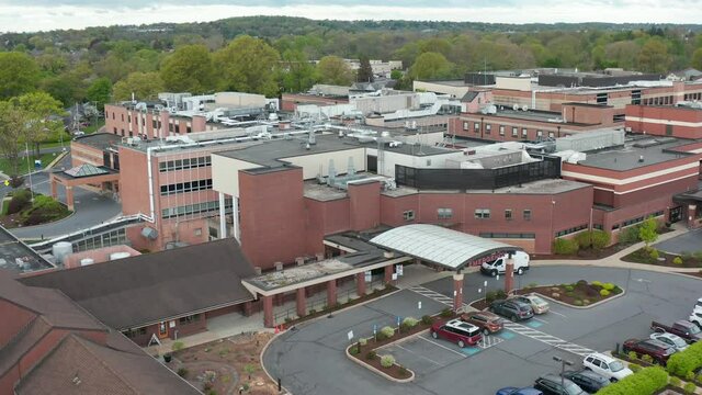 Wide angle aerial of hospital in USA. American healthcare system. Emergency exit and American flag. Insurance and ACA theme.