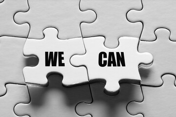 Fototapeta premium Jigsaw puzzle piece with the message we can. Togetherness, teamwork, solidarity, success and achievement