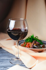 Creamy beef pasta made with egg noodles, beef, mushrooms and garnished with arugula and a glass of red wine.