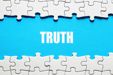 The word truth framed by jigsaw puzzle pieces. To discover or expose the truth, facts and reality