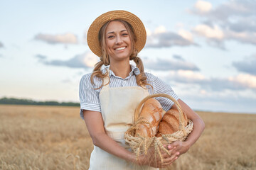 Female farmer standing wheat agricultural field Woman baker holding wicker basket bread product