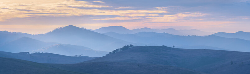 Fototapeta premium Mountains and hills in the morning haze, panoramic view