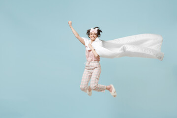 Full length young superhero woman win ear pajamas jam sleep eye mask rest at home jump high fly gesture wrap in blanket duvet isolated on pastel blue background Real heroes defend night bedtime you