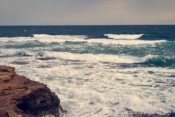 Sea waves bumping against the rocky shore