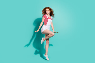 Full length body size view of attractive cheerful girl jumping enjoying isolated bright blue color background