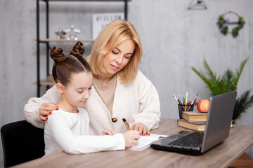 school, homework and distance education concept - school girl doing homework with her mother at home