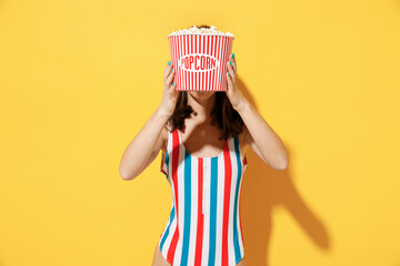 Happy young sexy woman slim body wear striped red blue one-piece swimsuit hold eat bucket of...