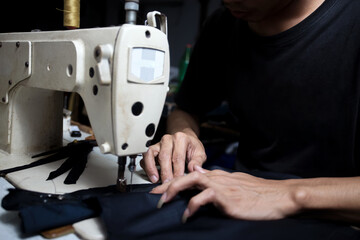 Midsection of man hands working with sewing machine.