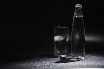Close up pouring purified fresh drink water from the bottle on table in living room. Drinking water. Mineral vitamin water. Healthy, mineral-rich, refreshing water.