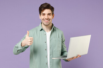 Young fun caucasian man in mint shirt white t-shirt using laptop pc computer chat online in social...