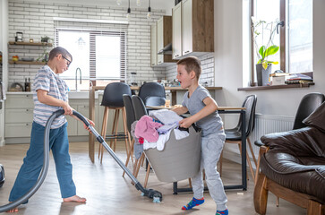Two little boys help with the laundry and cleaning of the house.