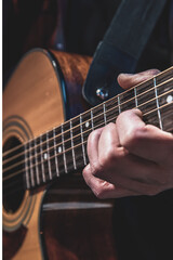 Obraz na płótnie Canvas Guitarist playing acoustic guitar in the dark close up.