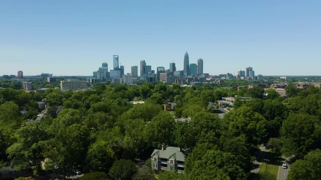 Aerial Hyperlapse Above Green Tree Tops with Charlotte Skyline in Background