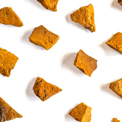 Naklejka premium chaga mushroom. broken pieces of birch tree chaga fungus for brewing natural medicinal antitumor, anti-inflammatory and antiviral detox tea, isolation on white background. regular pattern. square