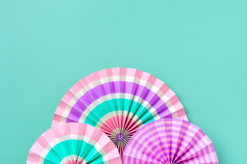 Traditional Japaneses festival paper fan with pink, turquoise, white stripes Birthday party, celebration holidays concept Abstract background