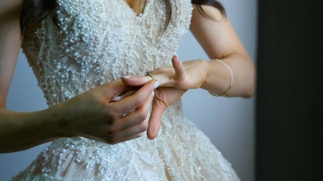 Beast day.  Close up of bride hand putting wedding ring  on her finger
