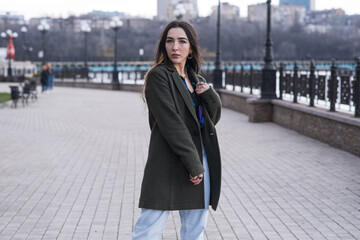 Portrait of a stylish and beautiful hippie girl in the park in cloudy weather