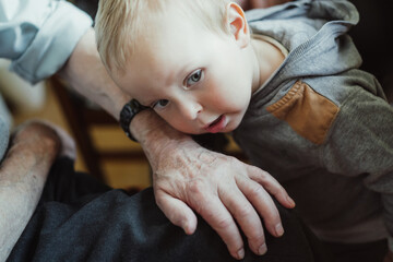 Time is ticking - relationship, generations. Little boy listens to watch ticking on great grandfather's hand.