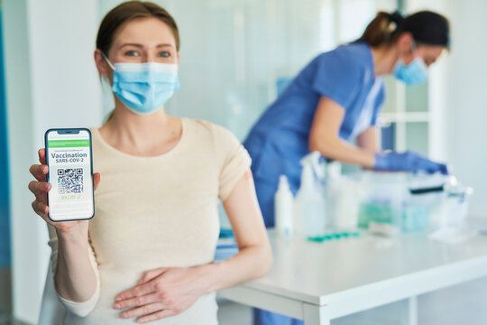 Pregnant Woman Holding Phone With Digital Vaccination Card