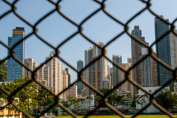 Skyscraper buildings and skyline of Hong Kong behind fence