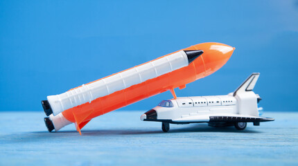 Toy space shuttle on blue background. Rocket launch