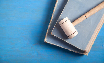 Judge gavel and book on the blue background.