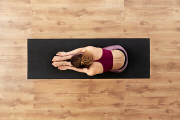 fitness, sport and healthy lifestyle concept - woman doing yoga exercise on mat at studio