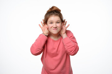 Studio portrait of cheerful young girl making funny face. White background
