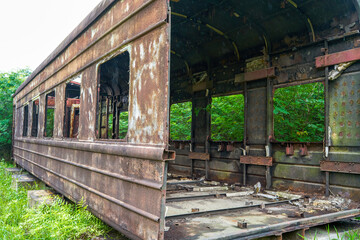 Fototapeta na wymiar A batch of rusty train carriages abandoned in the forest