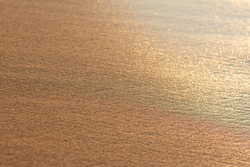 Sea sand with flat wet surface in the morning sunlight