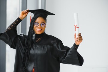 happy african american female student with diploma at graduation