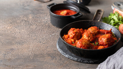 Homemade Meatballs in frypan with tomato sauce  on dark concrete table.Copy space