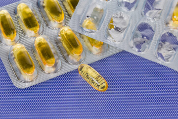 Yellow capsules in blister packing and one capsule lies separately