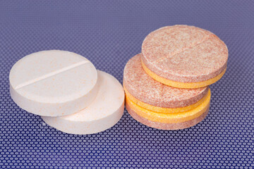 Effervescent tablets on blue surface, close-up in selective focus