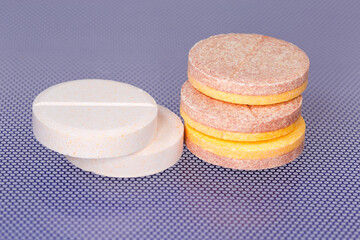 Effervescent tablets on blue surface, close-up in selective focus
