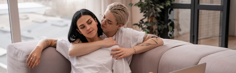 young lesbian couple chilling on sofa, banner