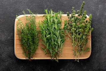 Fresh rosemary, thyme on a wooden board.