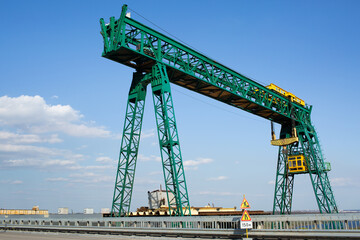 Fototapeta na wymiar Green gantry crane near the road bridge.
