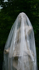 Statue of a woman wrapped in plastic for protection in a public park
