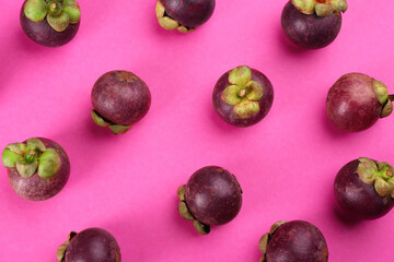 Fresh ripe mangosteen fruits on pink background, flat lay