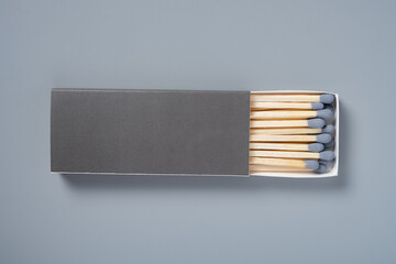 grey color matchbox and grey match sticks on a grey background