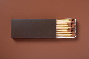 brown color matchbox and brown match sticks on a brown background
