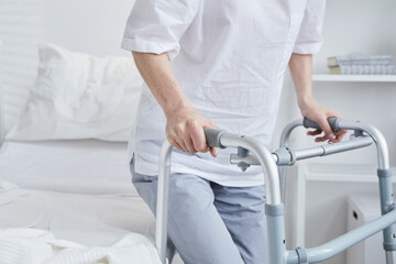 Obraz premium Close-up of patient standing up with the walker from the hospital bed