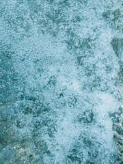 The texture of a seething river with many small bubbles.