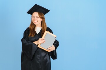 Beautiful woman wearing graduation cap and ceremony robe holding degree looking positive and happy standing and smiling with a confident smile.