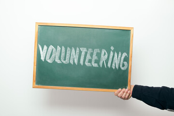 chalkboard with VOLUNTEERING handwritten in chalk